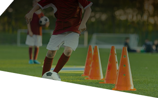 Jeune joueur dribblant entre les plots